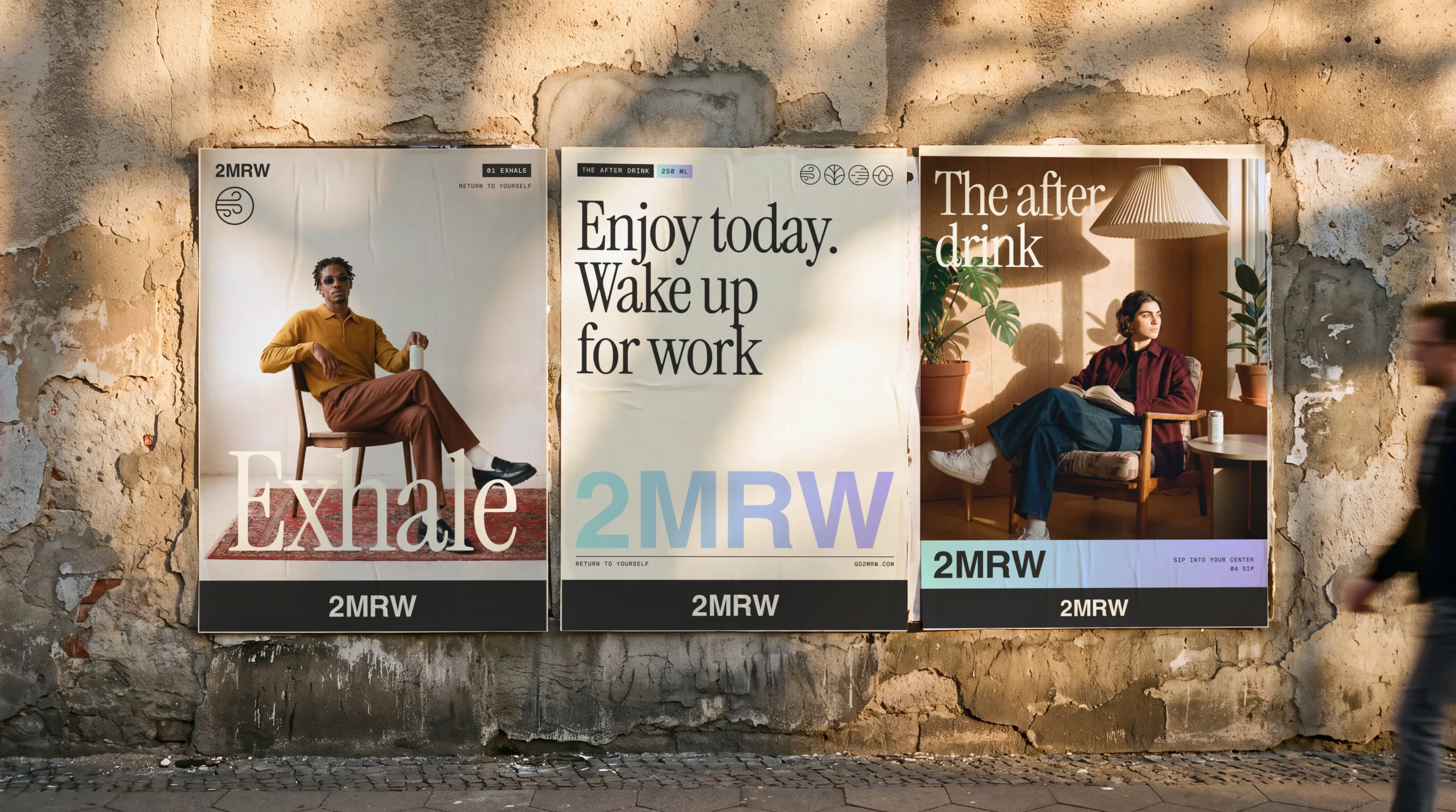 The three 2MRW posters pasted side by side on a weathered street wall in afternoon sun