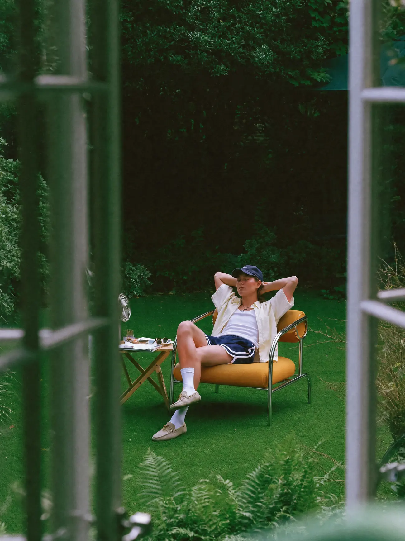 A lounger behind green railings