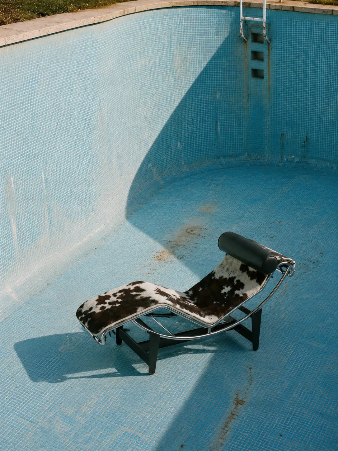 A weathered lounger in an empty swimming pool
