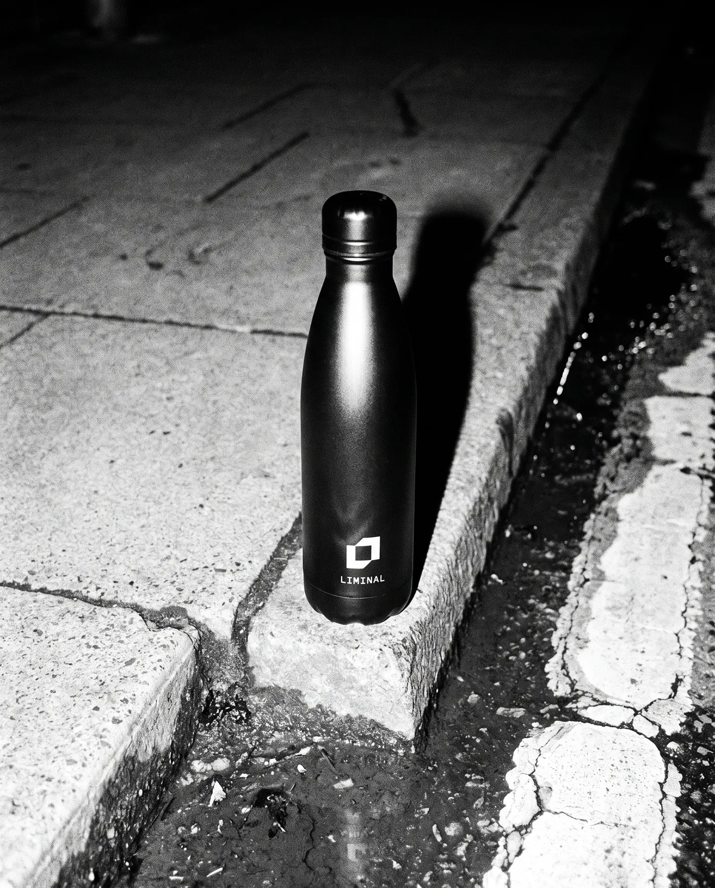 Black steel bottle with the symbol on a concrete kerb