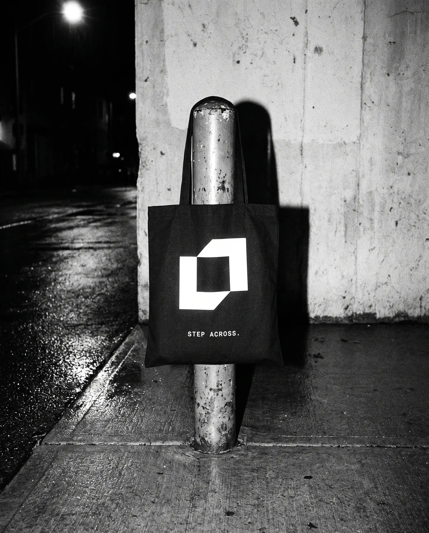 Black tote with the symbol hanging from a steel bollard
