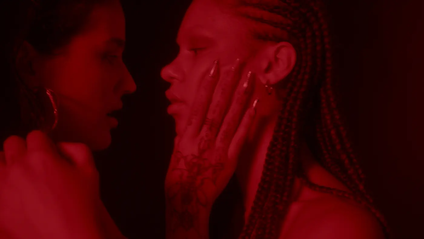 A hand pressed to a face, both figures in red profile
