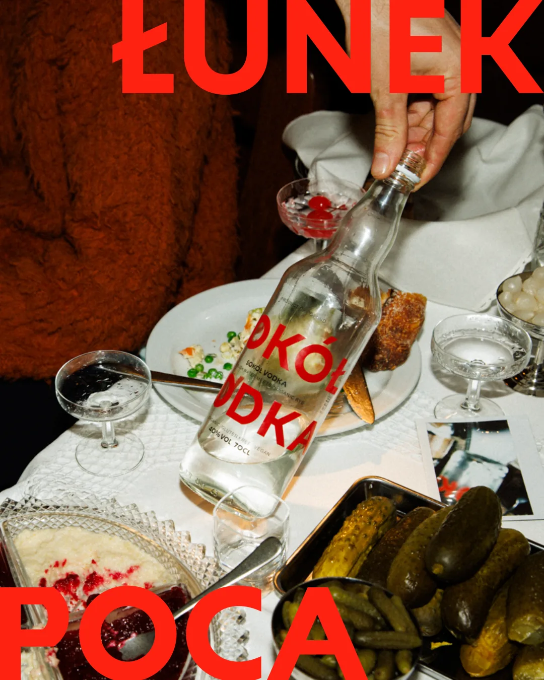 A Polish supper table with the word POCAŁUNEK split in red across the top and bottom of the frame.